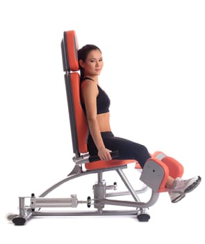 Young woman on hydraulic exerciser. Isolated on white