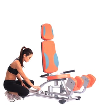 Sporty woman near isodynamic exerciser. Isolated on white