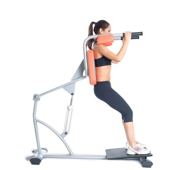 Beautiful slim woman trains on exerciser, isolated on white