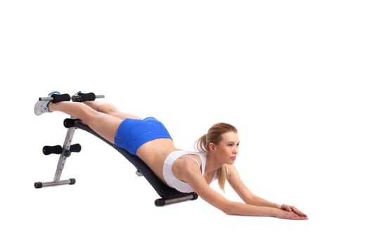 Young woman shakes press on exerciser, isolated on white