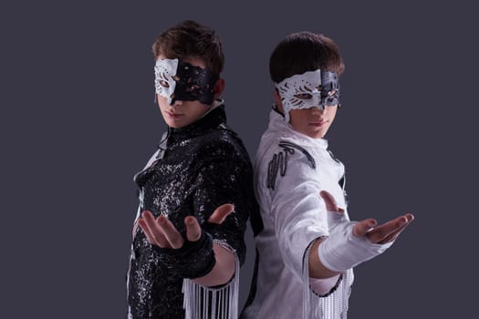 Portrait of attractive young guys in masks, on gray background