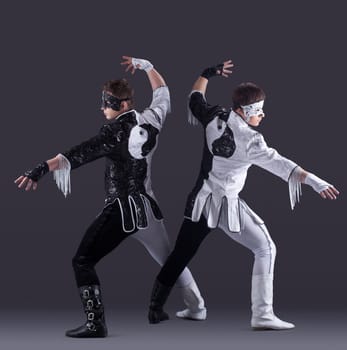 two men in carnival costumes posing in studio, on gray background