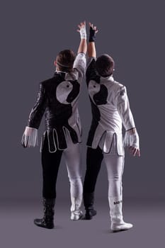 Guys posing in masquerade costumes on gray background