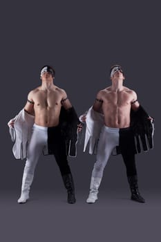 Handsome muscular guys take off their clothes, on gray background
