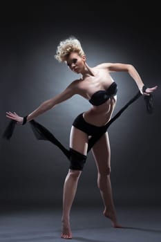 Full length portrait of slim blonde woman in black underwear