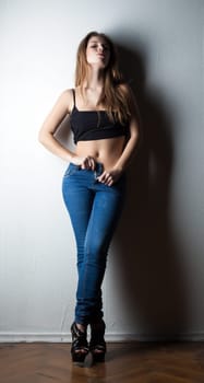 Image of sensual slim woman taking off jeans, close-up