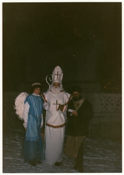 THE CZECHOSLOVAK REPUBLIC - CIRCA 1990s: Vintage photo shows people in costums the St. Nicholas, the Angel, and the Devil on the eve of St. Nicholas.