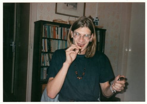 THE CZECHOSLOVAK REPUBLIC - CIRCA 1990s: Retro photo shows man smokes marijuana pipe at the party.