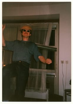 THE CZECHOSLOVAK REPUBLIC - CIRCA 1990s: Retro photo shows man dances at the home party.