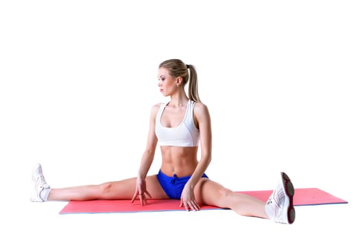 Athletic woman practices aerobics on mat in studio