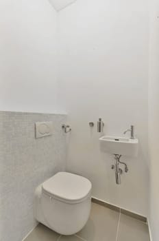 a bathroom with white tiles on the wall and toilet in the corner, there is a mirror above the sink