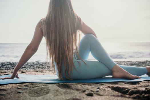 Middle aged well looking woman with black hair doing Pilates with the ring on the yoga mat near the sea on the pebble beach. Female fitness yoga concept. Healthy lifestyle, harmony and meditation.