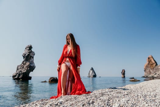 Woman travel sea. Happy tourist taking picture outdoors for memories. Woman traveler looks at the edge of the cliff on the sea bay of mountains, sharing travel adventure journey.