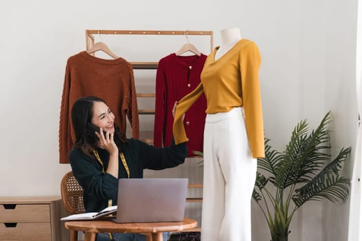 Female stylist Successful Fashion Business. Portrait of Smiling Asian Designer stylish standing and working at fashion studio. Portrait of fashion designer in office.