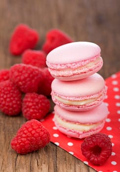 Pink raspberry macaron cookies on dark wooden boards