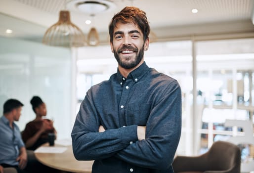 Im always on top of my game. Portrait of a young businessman standing in an office with his colleagues in the background