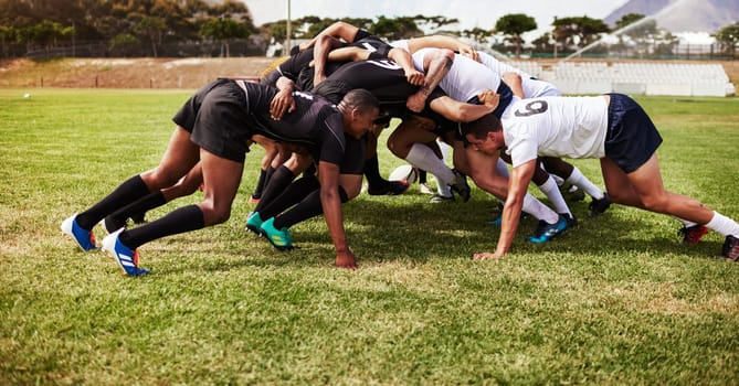 Where all of the power plays are. a group of young rugby players in a scrum on the field