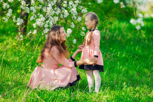 mother and daughter in nature in identical dresses