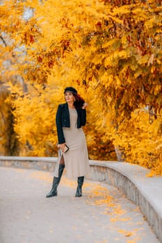 A woman walks outdoors in autumn, enjoys the autumn weather