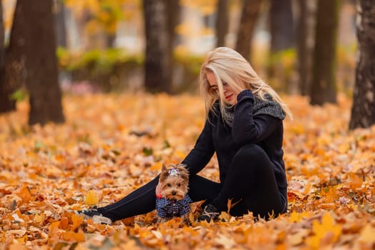 girl with her little dog in autumn park