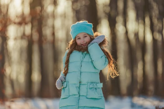 girl in turquoise clothes in a snowy forest