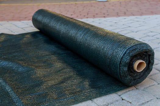 A roll of green shading netting. Artificial shading of plants or grapes.