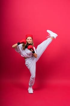 Cute little girl in boxing gloves on a red background studio