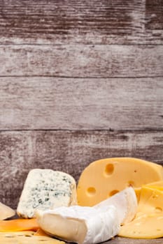 Mix of different type of cheese on wooden background. Healthy food. Snacks and products
