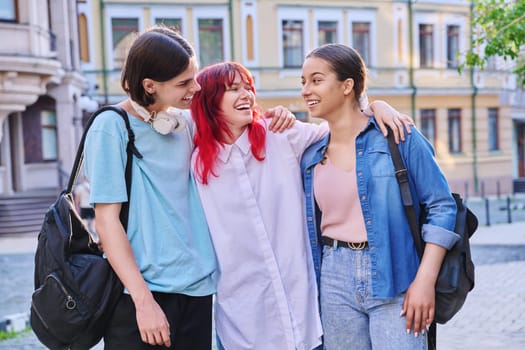 Happy smiling hugging teenage friends outdoor, on city street. Friendship, community, youth, lifestyle, leisure fun concept