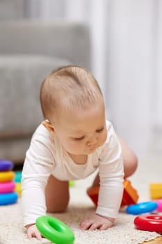 cute baby girl playing with colorful toy blocks at home