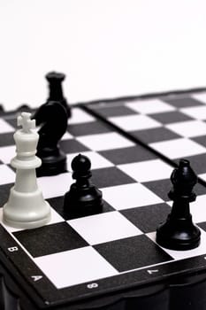Captured king of chess on a white background close up