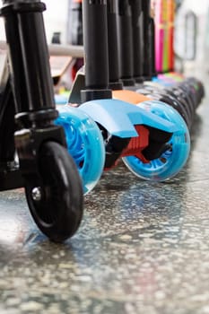 Wheels of various scooters in a row close up