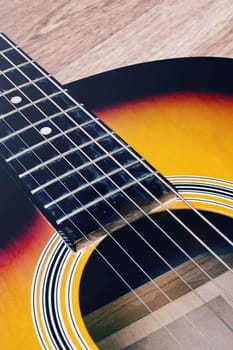 Acoustic guitar on a wooden background close up