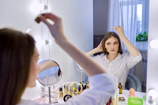 Young woman treating her hair using medical drops. Medicine for care and nutrition of hair, from hair loss.