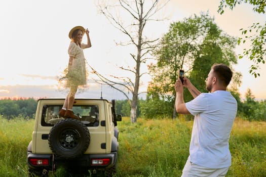 Summer family vacation together, traveling by car, a man photographing a woman on a smartphone. Middle age people, couple, relationship, leisure, trip vacation concept