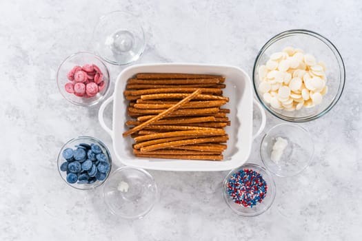 Flat lay. Ingredients in glass mixing bowls to prepare chocolate dipped pretzel rods for the July 4th celebration.