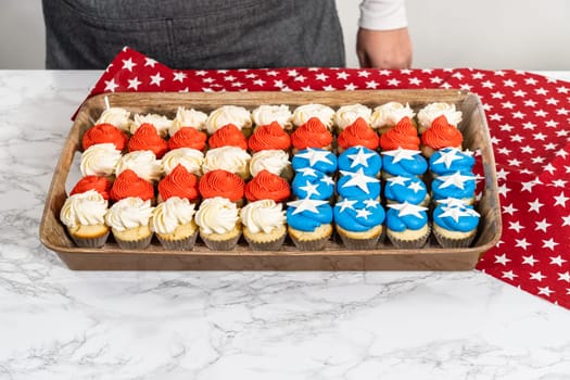 Arranging mini vanilla cupcakes in the shape of the American flag.