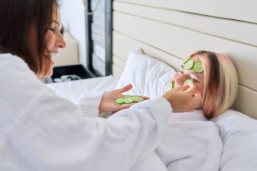 Relaxation together, beauty treatments. Mom and teenage daughter are taking care of face using natural cosmetics and cucumber masks. Beauty, clean spa skin care, parent teen child communication