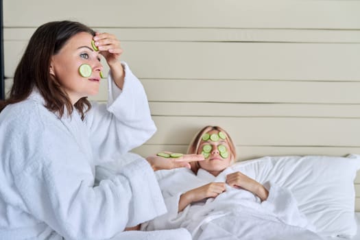 Relaxation together, beauty treatments. Mom and teenage daughter are taking care of face using natural cosmetics and cucumber masks. Beauty, clean spa skin care, parent teen child communication