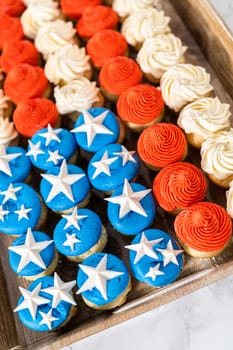 Arranging mini vanilla cupcakes in the shape of the American flag.