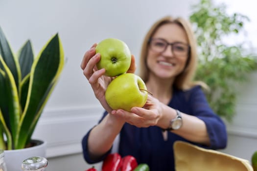 Green apples in the hands of a woman nutritionist, healthy eating, natural fruits, nuttriciology