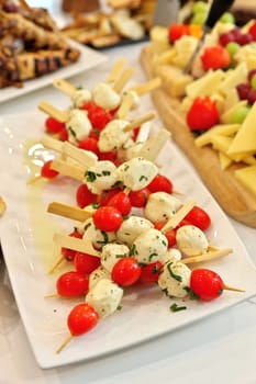 High angle view of Caprese salad skewers made of cherry tomatoes, bocconcini, basil, and balsamic reduction