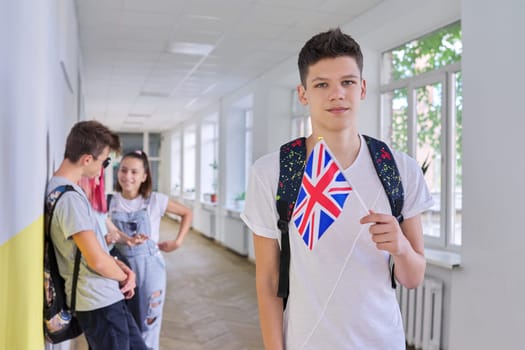 Teenager student with British flag, school corridor group of students background. UK Kingdom England, school college education, youth people concept