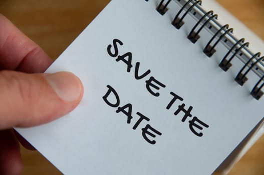 Top view of Save The Date text on white notepad. Business concept.