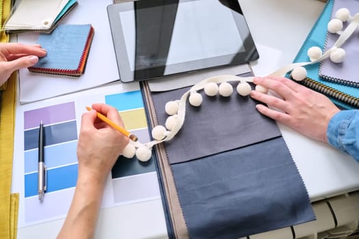 Interior design, fabric samples sketches digital tablet designers hands choosing materials.