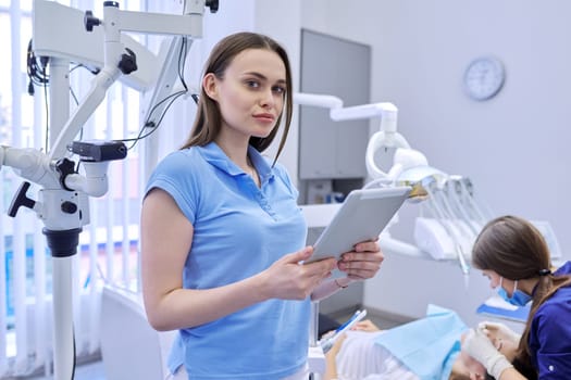 Portrait of dentist doctor with digital tablet, female working with computer. Healthcare dentistry medicine, Dental clinic, patient visit and checkup by dentist background