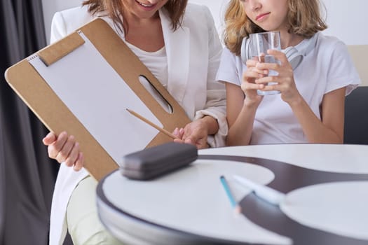 Children psychology psychotherapy mental health. Kid at meeting with female psychologist, specialist social worker talking looking at childs drawing in office