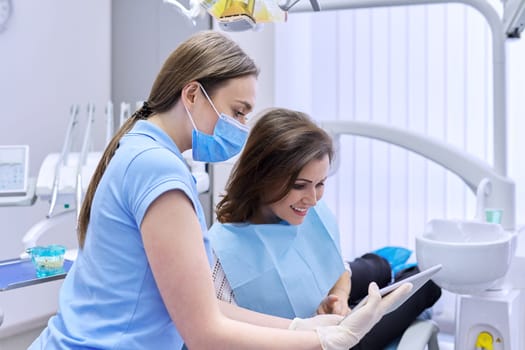 Dentistry, dental treatment, woman doctor dentist consults patient in chair, smile and talk. Medicine, dentistry and health care concept