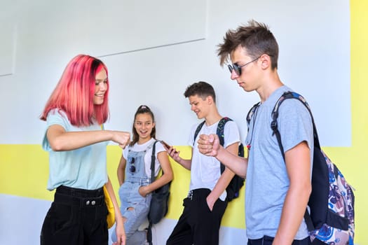 Teenagers in school greeting hand gestures when meeting. Friendship, youth, lifestyle, communication in college school