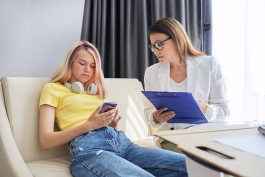 Psychologist counseling teenage girl in office. Visit and counseling of professional mental and social therapist. Psychology, teenager, problem, trauma, mental health of adolescents concept